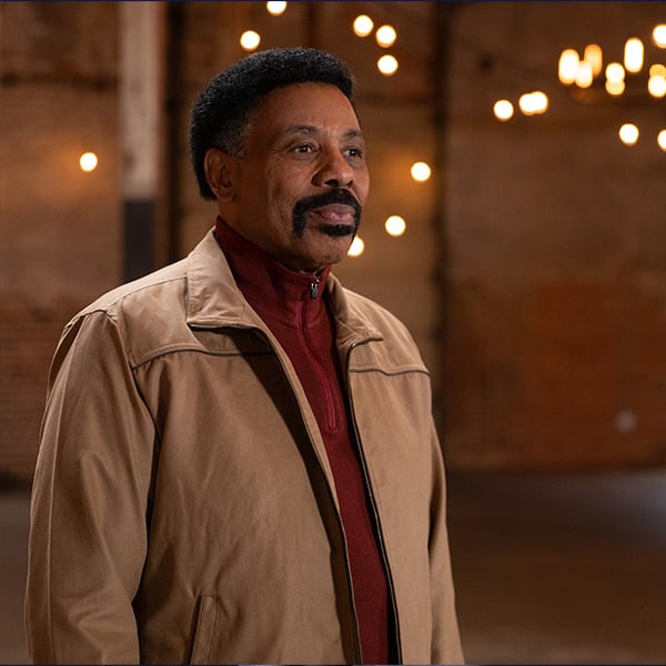 Dr. Tony Evans standing in room with twinkle lights behind him.